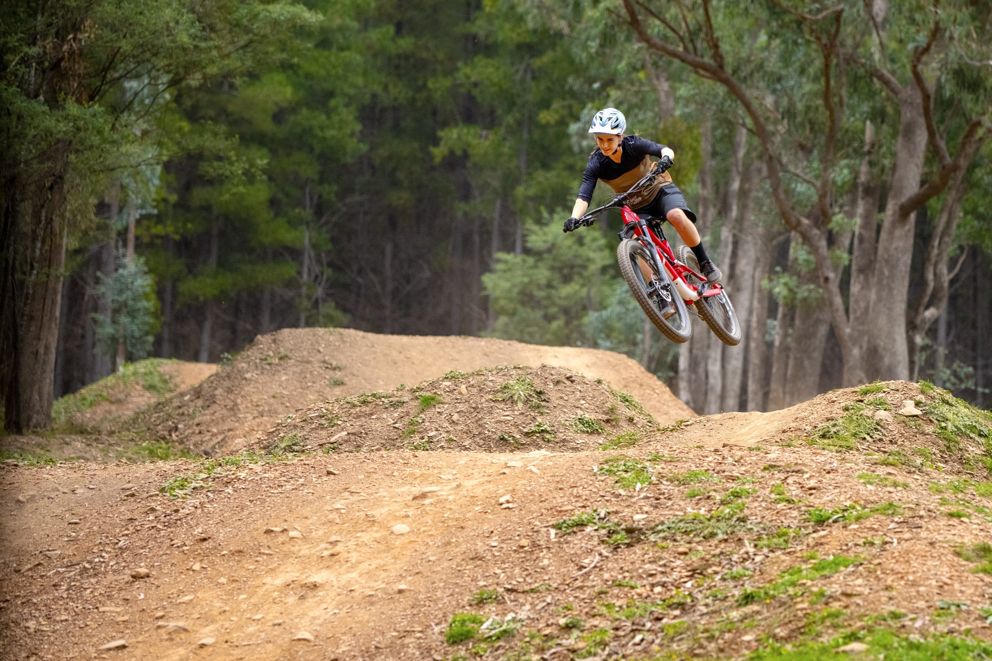 Cyclist riding over jumps at Mystic Bike Park