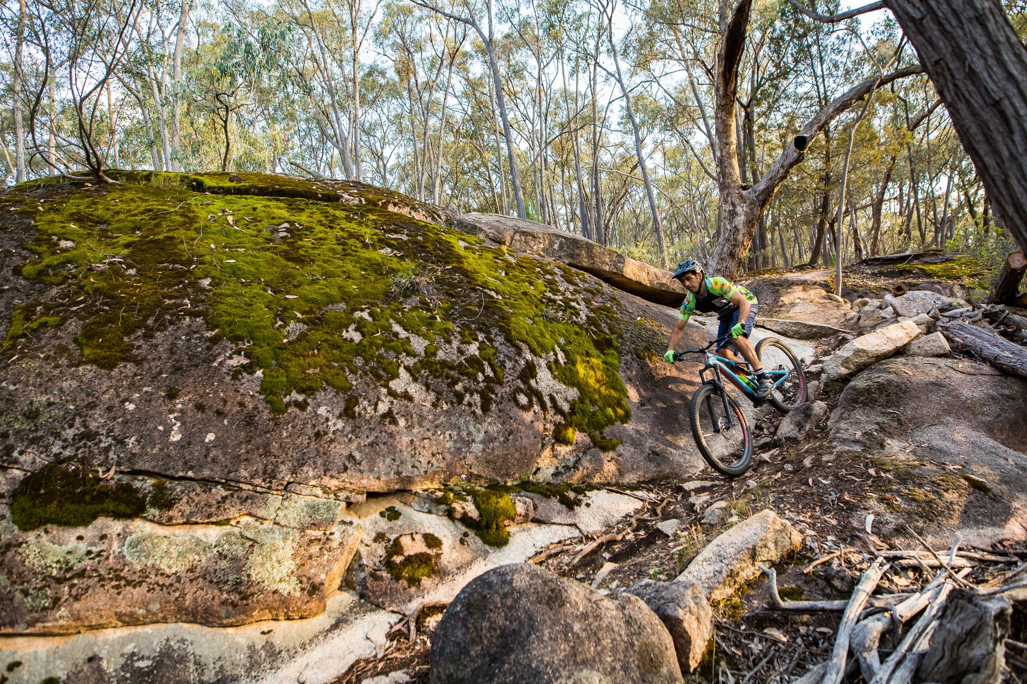 Cyclist riding around Beechworth's epic granite boulders on mountain bike singletrack