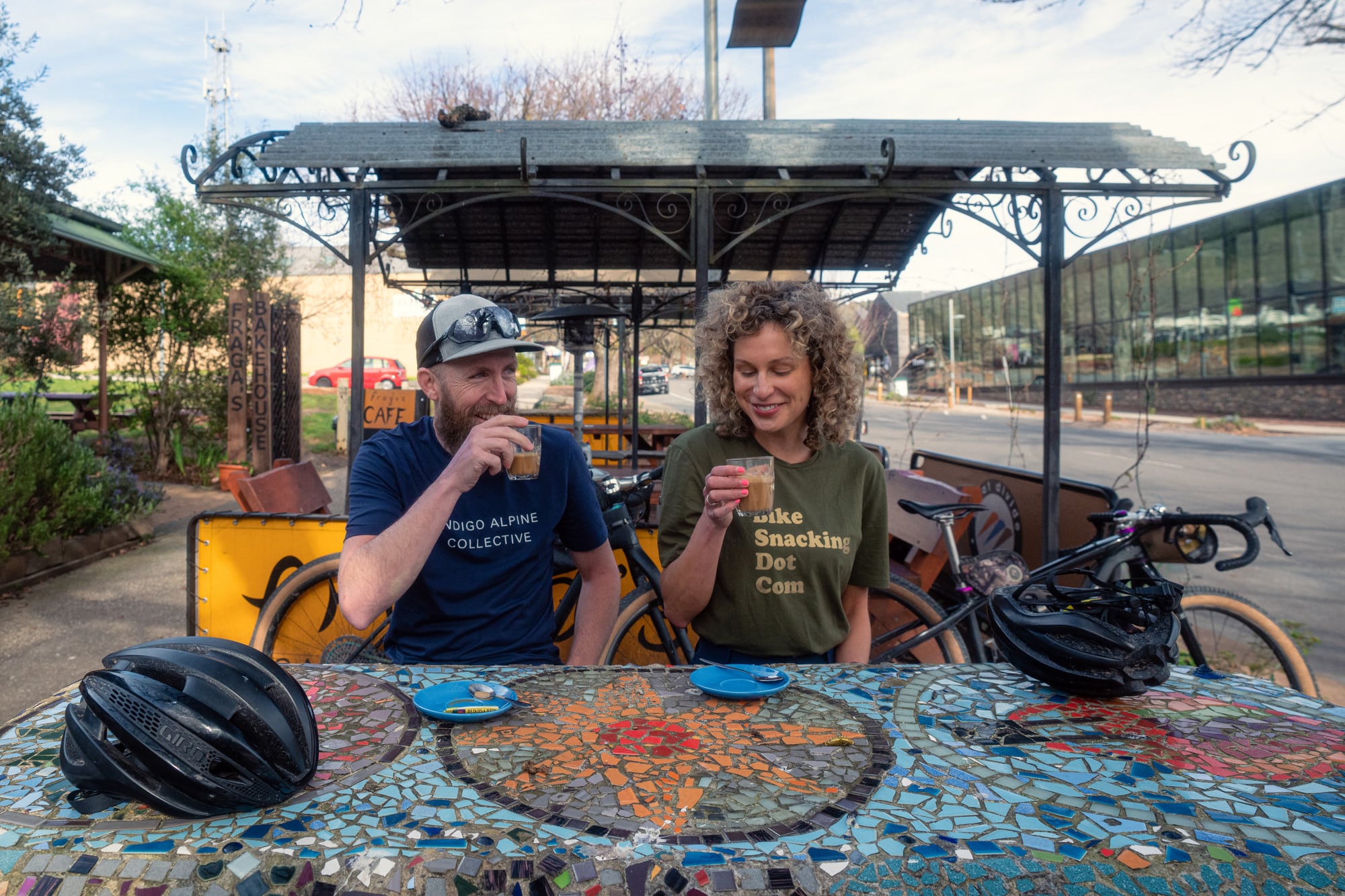 Two cyclists drinking coffee at a table in Marysville