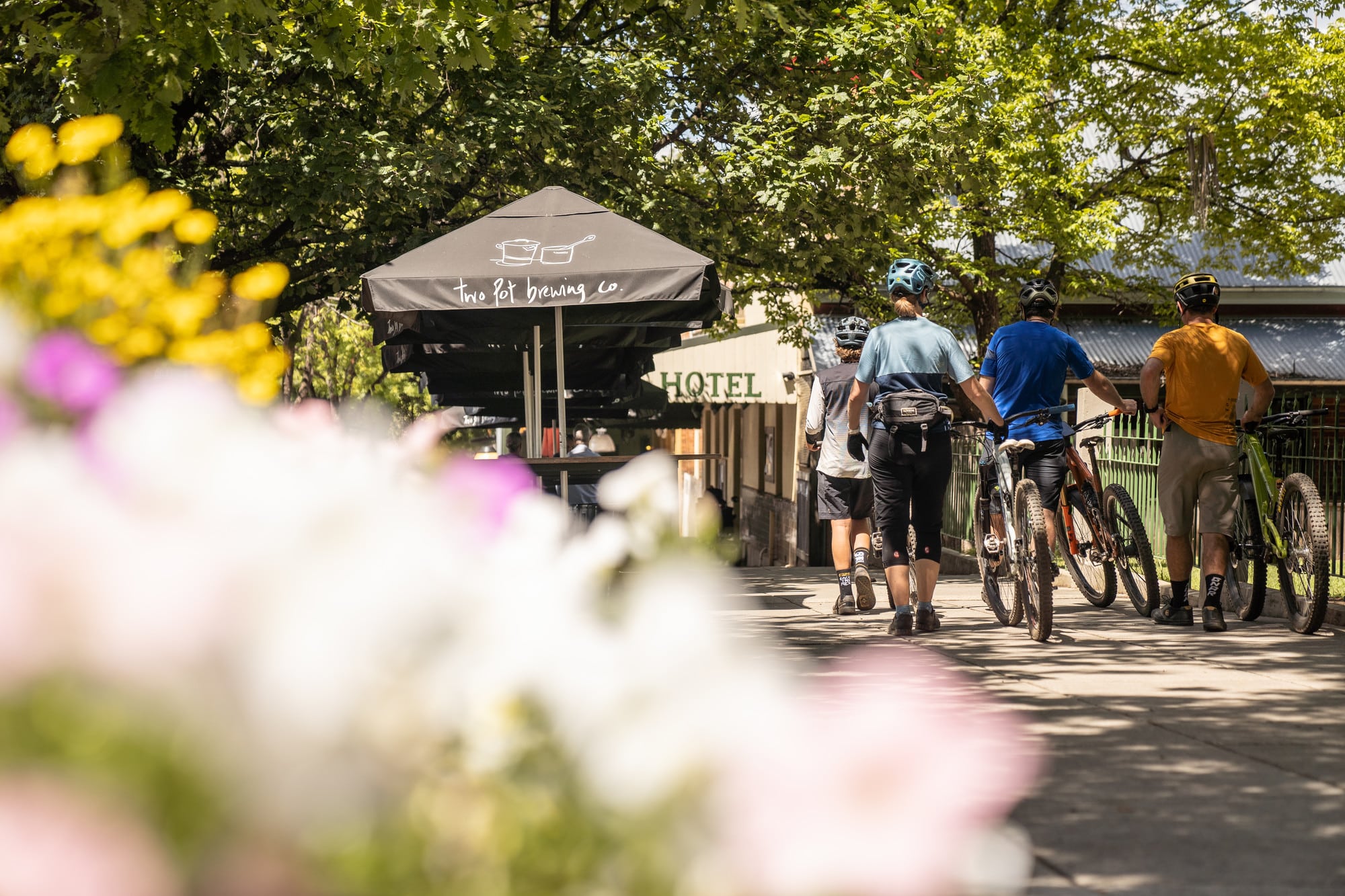 Cyclists rolling their bikes through the historic streets of Yackandandah