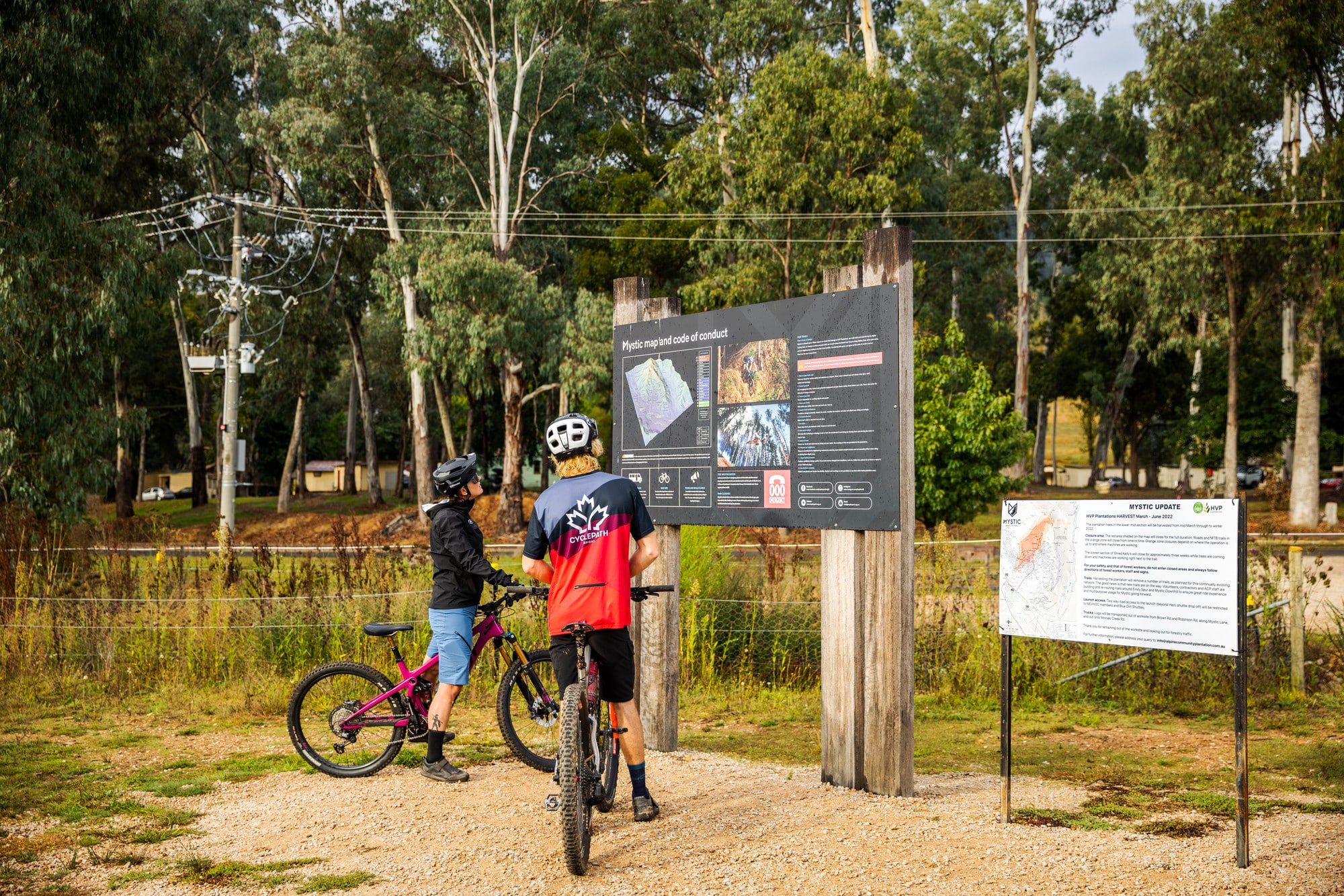 Two cyclists reading the trailhead map at Mystic Bike Park