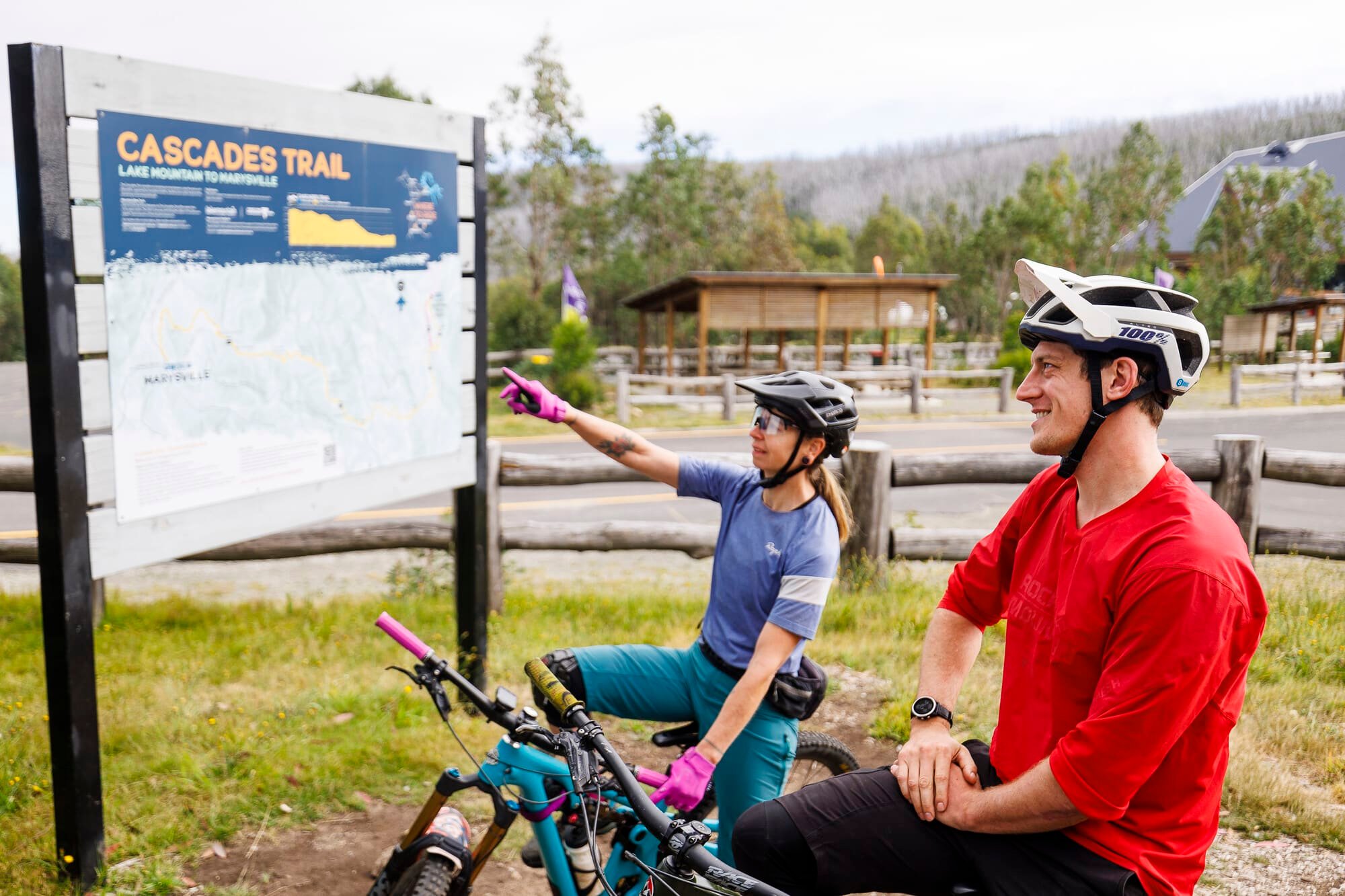 Two cyclists planning their ride on the Cascades Trail