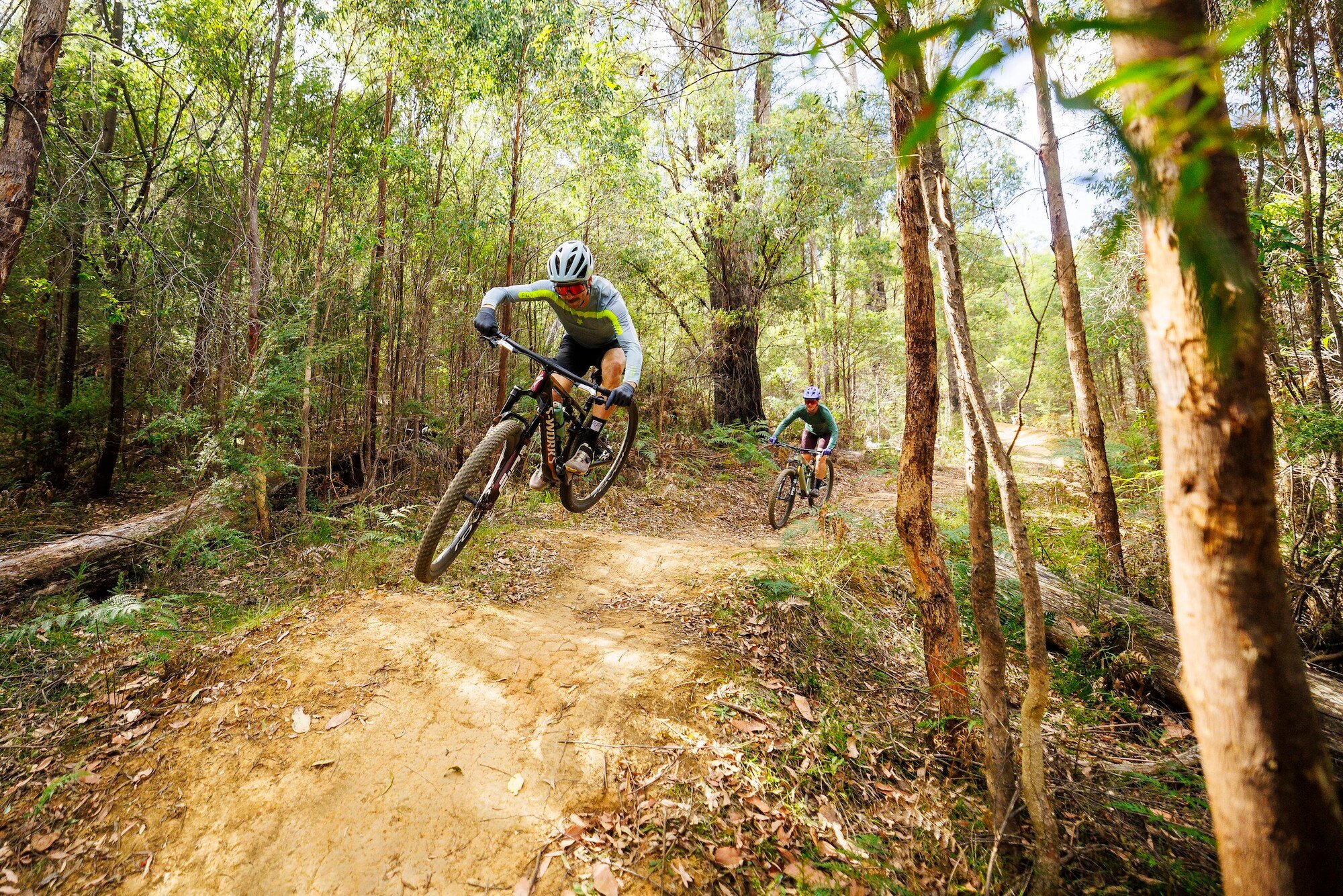 Two cyclists jumping over rollers at Buxton MTB Park