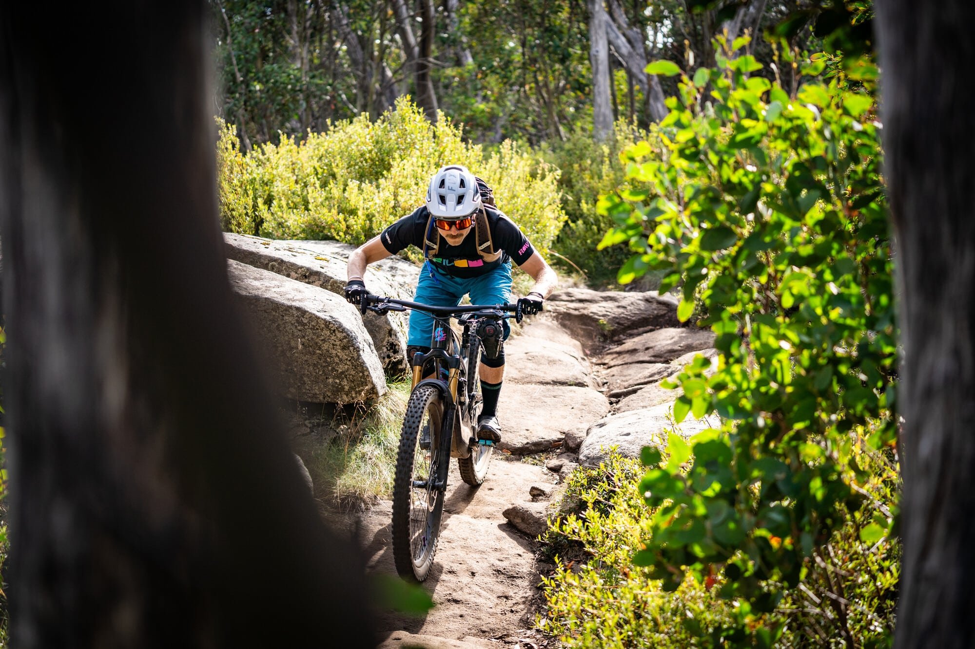 Cyclist riding granite rock alpine trails at Lake Mountain Bike Park