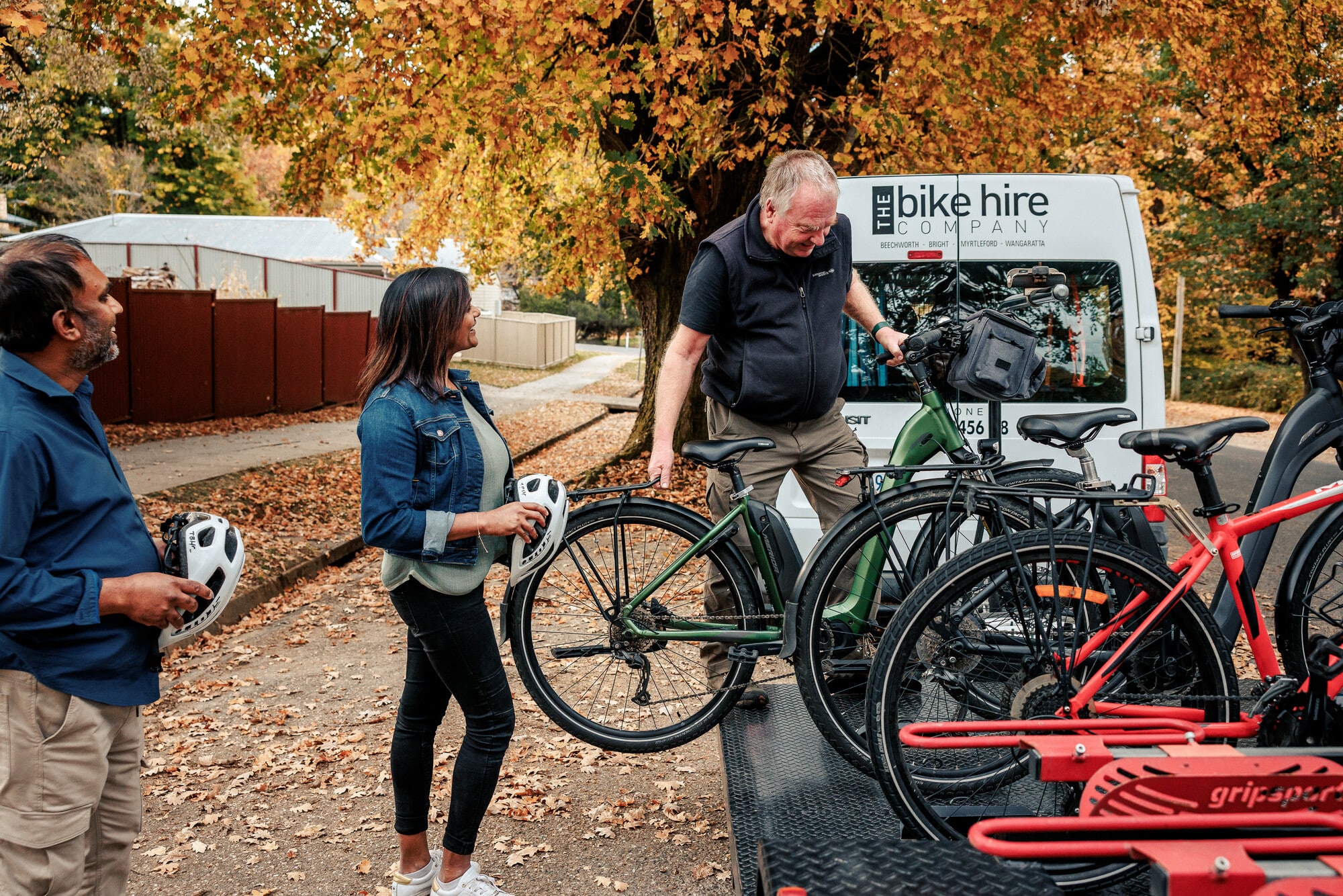 Couple having their bikes loaded onto a pre-booked bike shuttle in Yackandandah on the Beechworth to Yackandandah Rail Trail