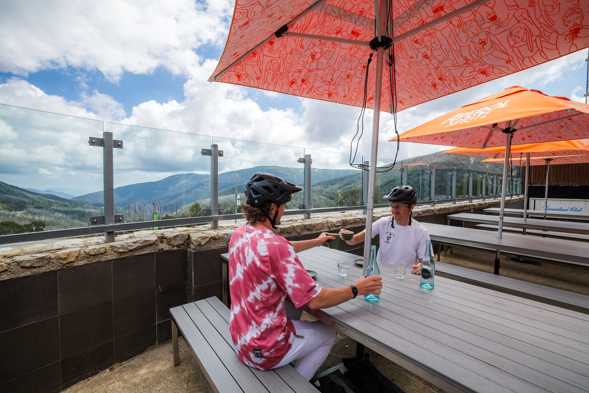 Two cyclists drinking coffee at a cfae in falls Creek